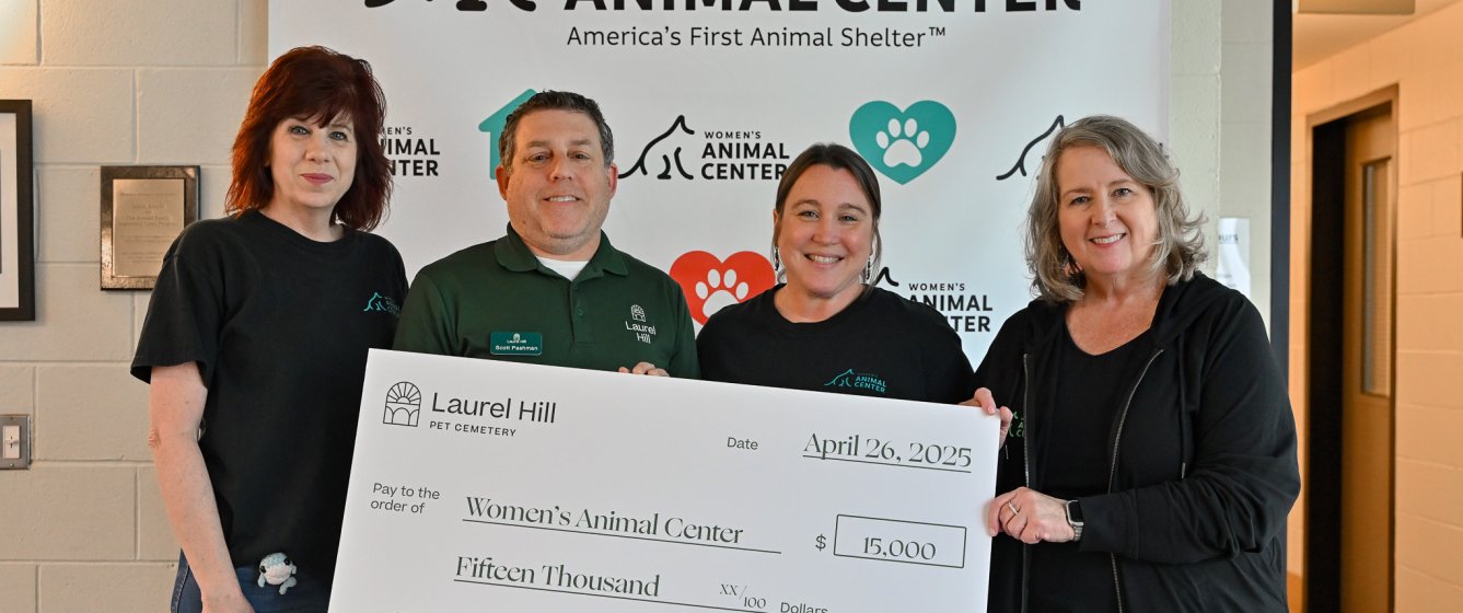 Four people standing with a check
